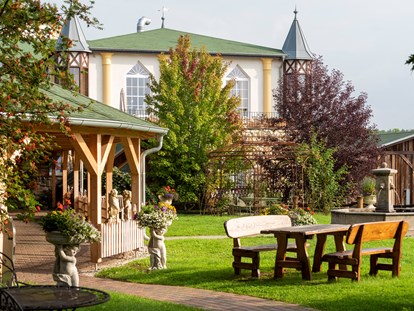 Luxusurlaub - Bar: Hotelbar - Außenansicht mit Brunnenwiese - Wellnesshotel Seeschlösschen - Privat-SPA & Naturresort