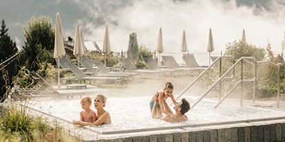 Luxusurlaub - Saunalandschaft: Infrarotkabine - Oberstdorf - Familie im Outdoor-Whirlpool - Schlosshotel Fiss