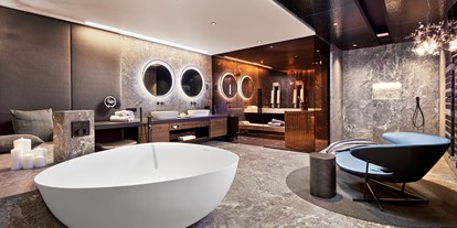 Luxusurlaub - Badezimmer der Luxury-Suite mit eigener Sauna, freistehende DUO-Badewanne mit Regensystem, 
Wärmebank und Relax-Bereich - 5-Sterne Wellness- & Sporthotel Jagdhof