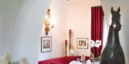 Luxusurlaub - Langschläferfrühstück - St. Leonhard (Trentino-Südtirol) - Behäbiges weißes Kreuzgewölbe wechselt mit Balken- und Holzdecken in den getäfelten Stuben des Hanswirt in Rabland, die immer wieder mit Nischen überraschen. Jede Stube und Nische ist besonders. Gemeinsam sind die hochwertigen Stoffe von Vorhängen und Tischdecken, die ausgewählt stilvolle Tischdekoration und Blumenarrangements. Antike und moderne Kunstgegenstände erfreuen auf Schritt und Tritt. Die Gurschler-Stube mit dem Fresko aus dem 16. Jahrhundert trägt zurecht ihren Namen. Zahlreiche Kunstwerke von Friedrich Gurschler, dem zeitgenössischen Schnalser Künstler und Freund des Hauses, prägen den Raum. - Hotel Hanswirt