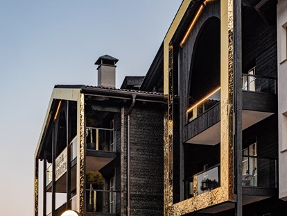 Luxusurlaub - Saunalandschaft: finnische Sauna - Moderne Architektur mit verkohltem Holz und goldenen Rahmen - Alpin Garden Luxury Maison & Spa
