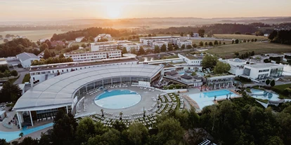 Luxusurlaub - Bar: Poolbar - Die weitläufige Thermenanlage des Spa Resort Geinberg mit 4*S Hotel im Hintergrund. - 4*S Hotel Spa Resort Geinberg