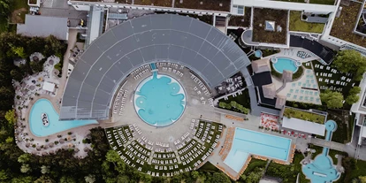 Luxusurlaub - Bar: Poolbar - Therme Geinberg aus Vogelperspektive mit Karibik-Lagune, Thermal-Becken outdoor, Sport-Becken, Kaskaden-Becken und Karibischer Saunawelt. - 4*S Hotel Spa Resort Geinberg
