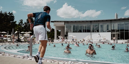 Luxusurlaub - Bar: Poolbar - Aqua Gymnastik im Thermal-Becken outdoor. - 4*S Hotel Spa Resort Geinberg