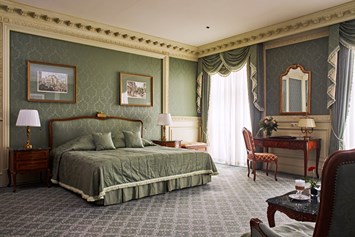 Luxushotel: Die Suiten sind luxuriös ausgestattet und bieten eine gemütliche Couch-Ecke und einen Schlafbereich mit Doppelbett oder 2 Einzelbetten. Die Dekoration, in sanftem Grün gehalten, trägt zu einer sehr ruhigen, entspannten Atmosphäre bei. - Grand Hotel Wien