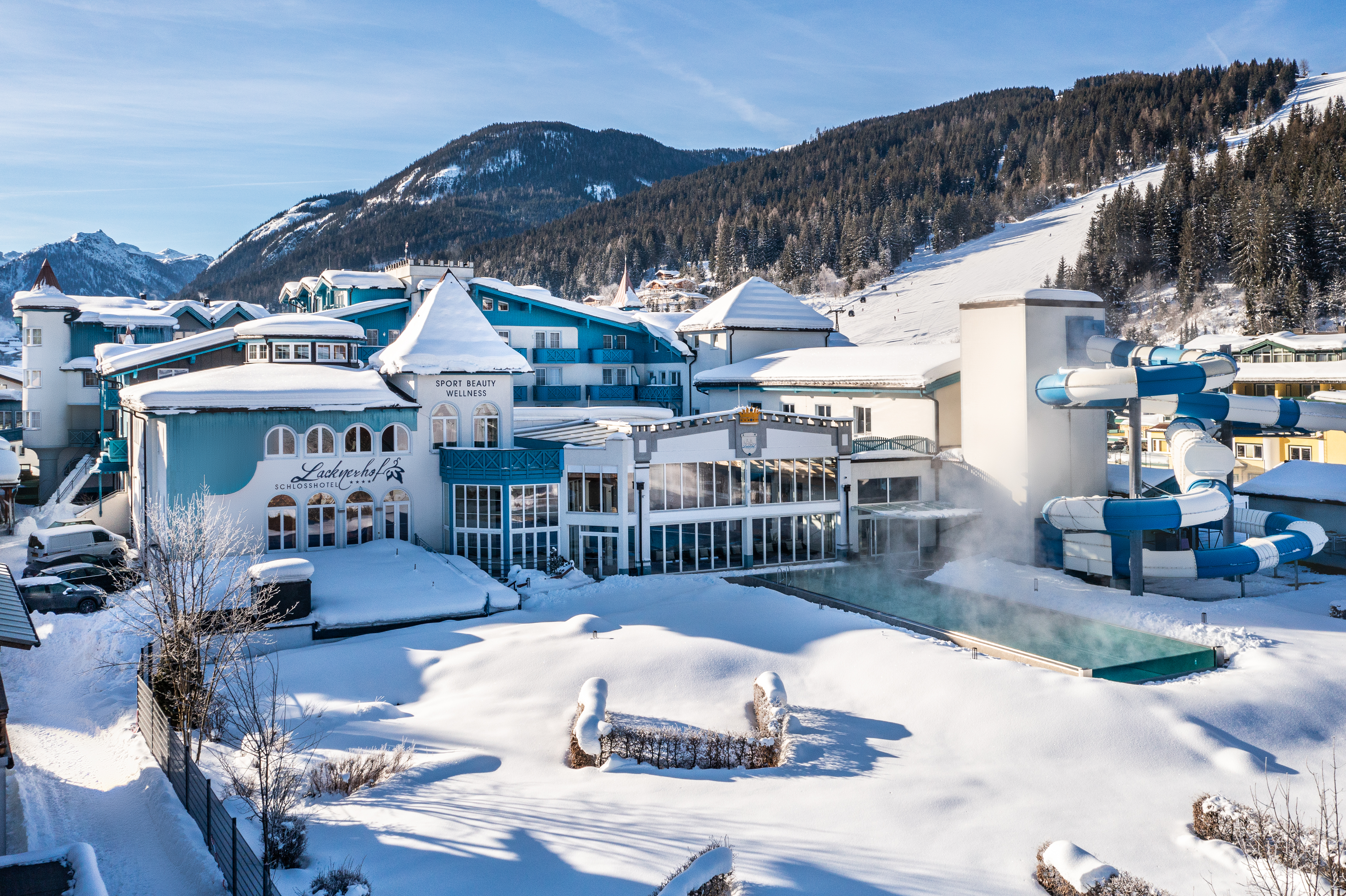 Luxusurlaub - Salzburg - Schlosshotel Lacknerhof mit Außenpool und Schipiste im Hintergrund. - Schlosshotel Lacknerhof****S Flachau