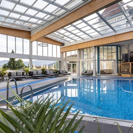 Luxushotel: Schwimmbad mit Entspannungsliegen und Cabrio-Dach! - Schlosshotel Lacknerhof****S Flachau