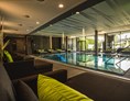 Luxushotel: Indoor Infinitypool mit großer Glasfront zum Ritzensee - Ritzenhof****S - Hotel & Spa am See