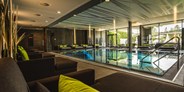 Luxusurlaub - Saunalandschaft: Textilsauna - Indoor Infinitypool mit großer Glasfront zum Ritzensee - Ritzenhof****S - Hotel & Spa am See