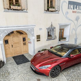 Luxushotel: Hoteleingang mit Aston Martin - In Lain Hotel Cadonau