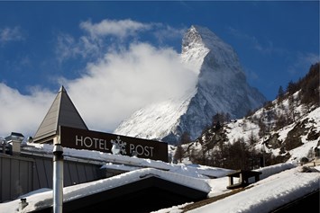 Luxushotel: Hotel Aussenansicht Winter - Unique Hotel Post Zermatt