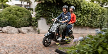 Luxusurlaub - Völlan - Vespa fahren. Italienischer geht’s nicht. Vespas sind Sommer und Lifestyle in einem. Für viel Fahrvergnügen mit italienischem Flair reservieren wir für unsere Motorrad Liebhaber eine unserer beiden Vespas für eine Spritztour. Dabei verschafft ein Korb voller Südtiroler Köstlichkeiten wunderbare Momente für ein romantisches Picknick. Bei blauem Himmel und Sonnenschein auf dem Gebirgspass Halt machen, das atemberaubende Panorama genießen, den Helm abnehmen und sich den Bergwind der nahen Gletscher ins Haar fahren lassen. Unsere kurvenreichen Berg- und Passstraßen voll auskosten und das Glück ist vollkommen. Sich in die Arme nehmen, die Wolken beobachten, den Grillen zuhören und gemeinsam Tagträumen. Im Moment leben und die romantische Auszeit genießen. - Hotel Hanswirt
