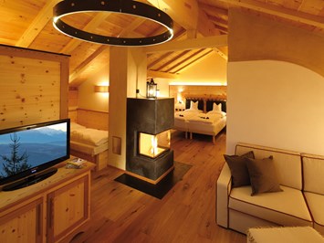 Tirler - Dolomites Living Hotel Zimmerkategorien Wärme strahlt diese Suite aus, in der Sie sich sofort zu Hause fühlen werden. Suite – 58 m²