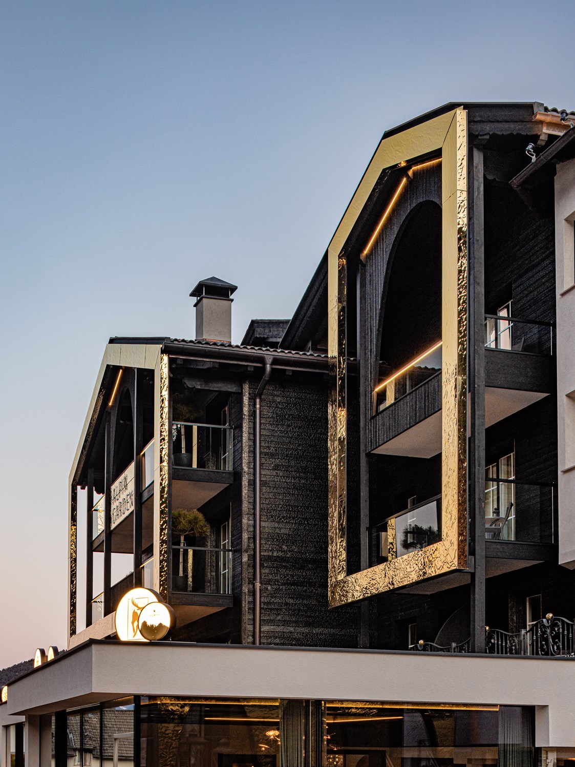 Luxushotel: Moderne Architektur mit verkohltem Holz und goldenen Rahmen - Alpin Garden Luxury Maison & Spa